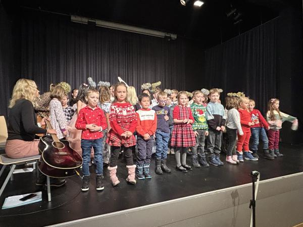 Die Kinder der VS Hönigsberg singen mit ihrer Lehrerin ein Lied auf der Bühne. 