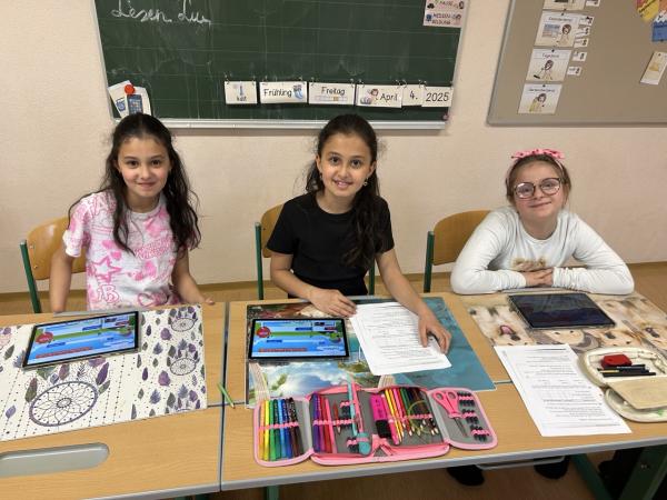 Kinder sitzen in einer Klasse vor Tablets