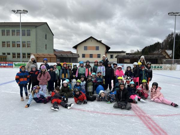 Kinder und Lehrerinnen stehen am Eislaufplatz in Langewang 