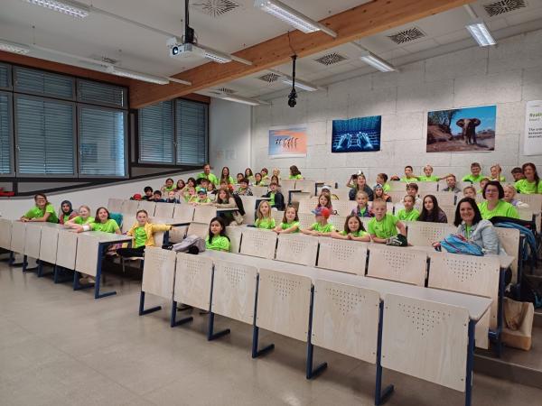 Kinder sitzen in einem Hörsaal