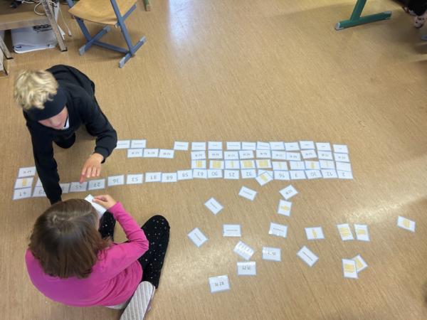 Auf dem Foto spielen zwei Kinder mit Mathematikkärtchen