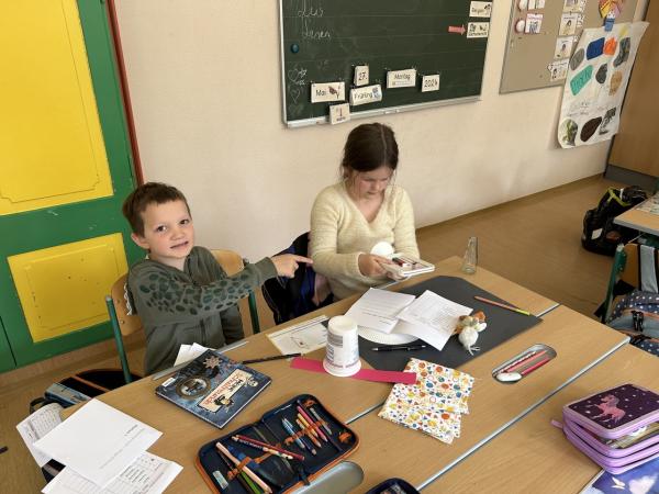 Kinder sitzen in einer Klasse vor Laptops