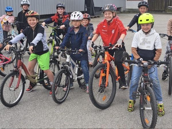Kinder sitzen auf ihren Rädern mit Helm