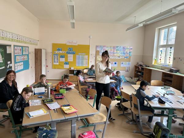 Frau Engelbogen liest ein paar Kindern ein Buch vor 